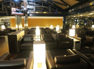 a room with black leather couches and a television