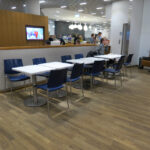 a group of people sitting at tables in a room with a wood floor