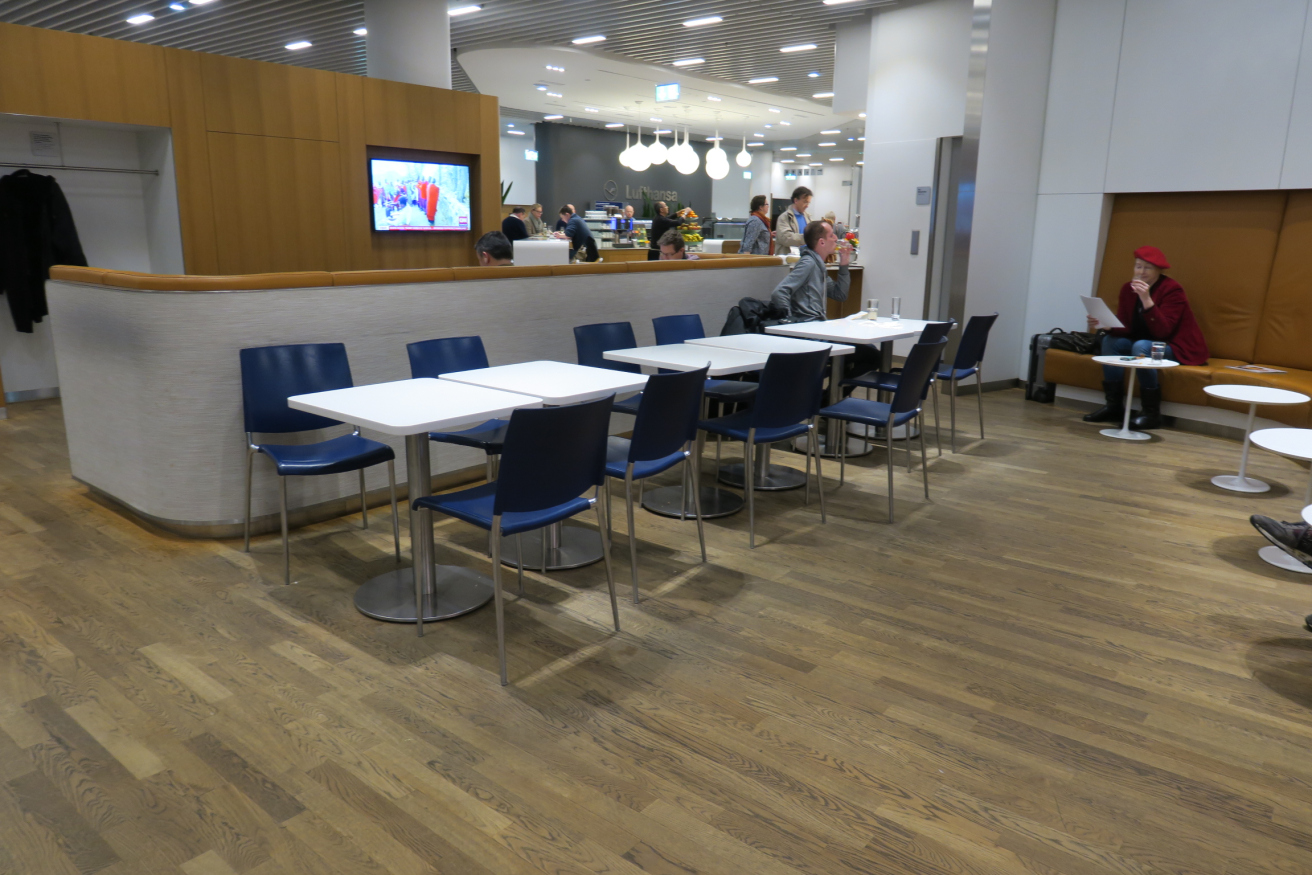 a group of people sitting at tables in a room with a wood floor