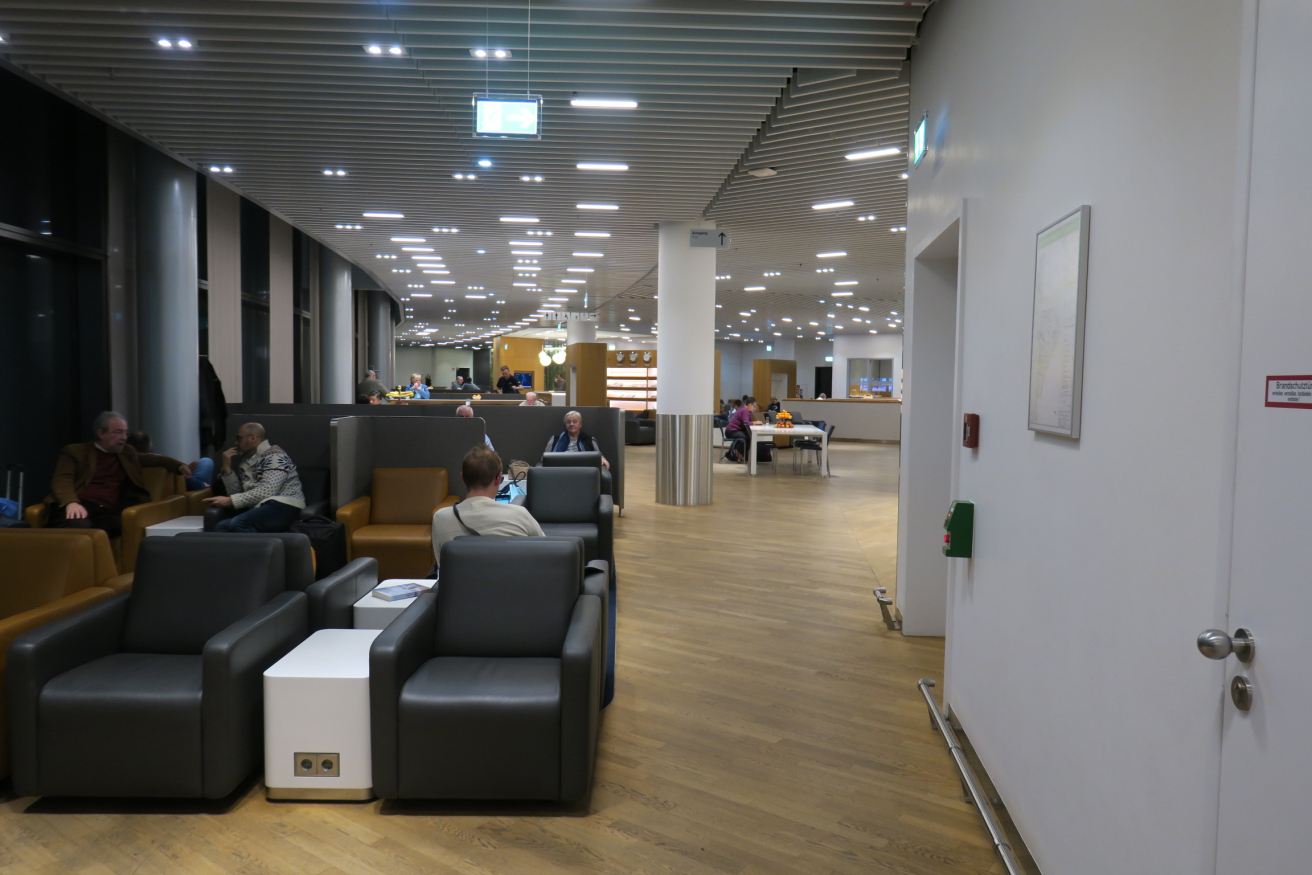 people sitting in a room with chairs and tables