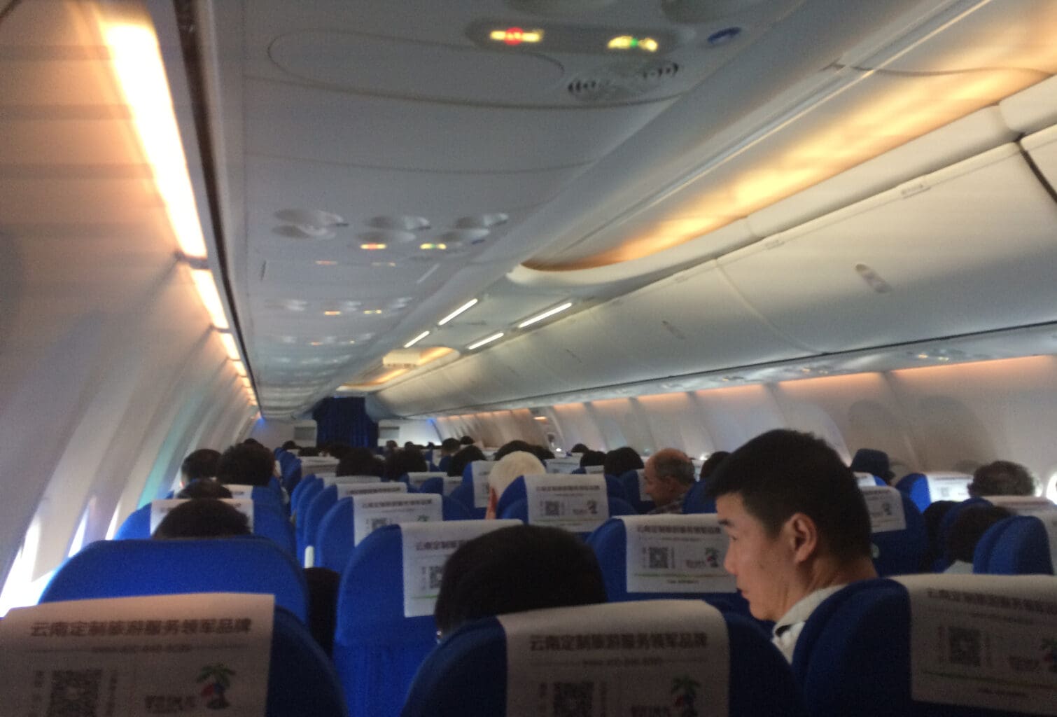 people sitting in an airplane with signs on them