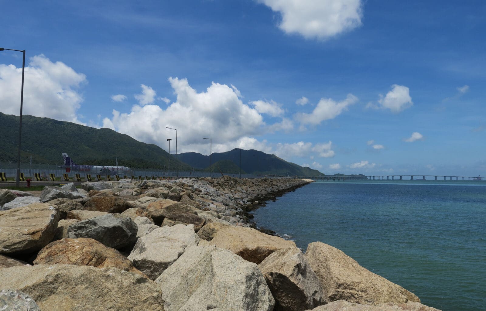 a rocky shore with a bridge over the water