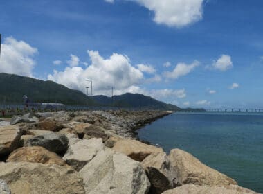 a rocky shore with a bridge over the water