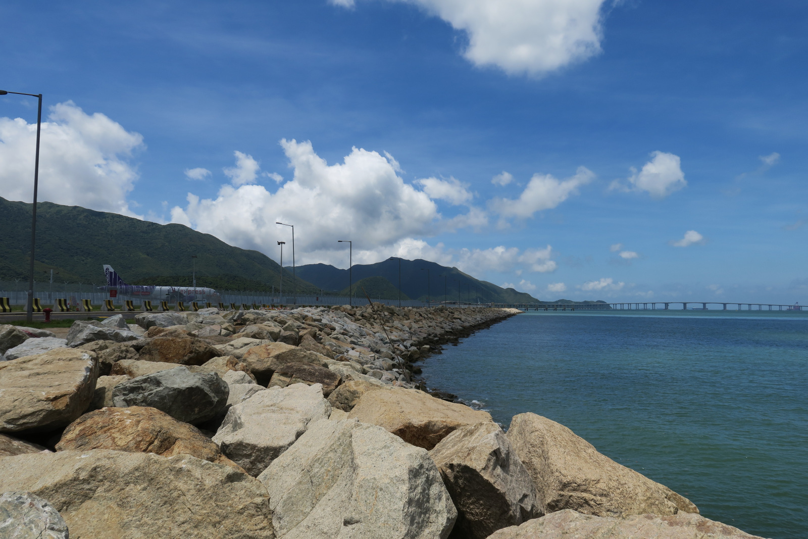 a rocky shore with a bridge over the water