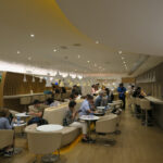 a group of people sitting at tables in a room with lights