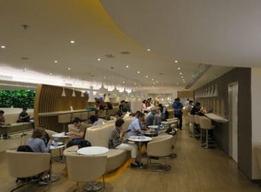 a group of people sitting at tables in a room with lights