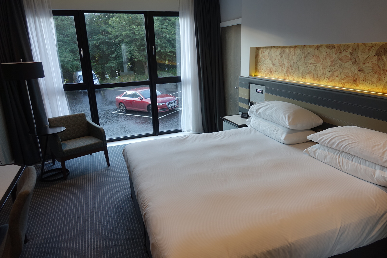 a bed with a chair and a table in a hotel room