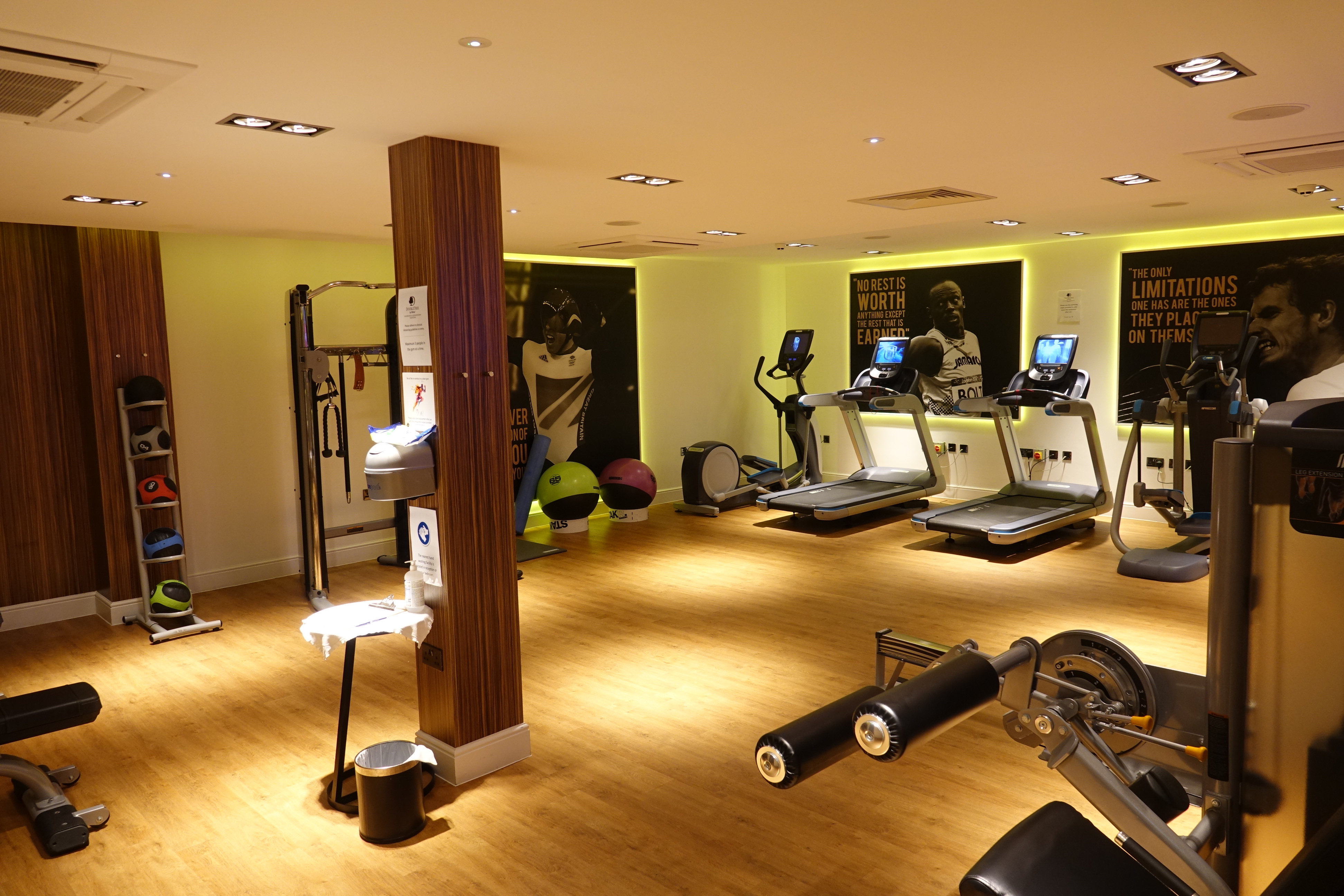 a room with exercise equipment and a wood floor