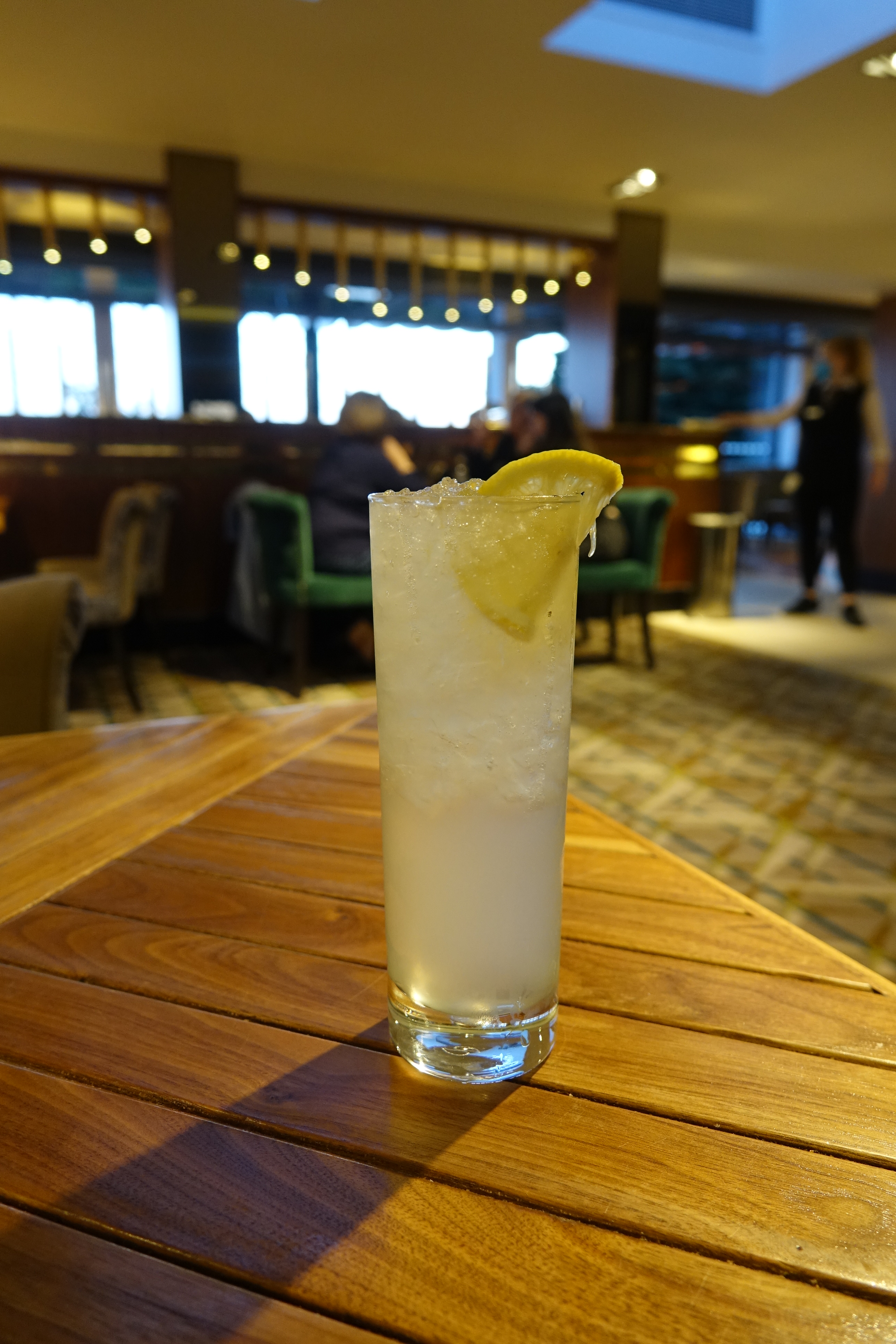 a glass of liquid with a lemon slice on top of it