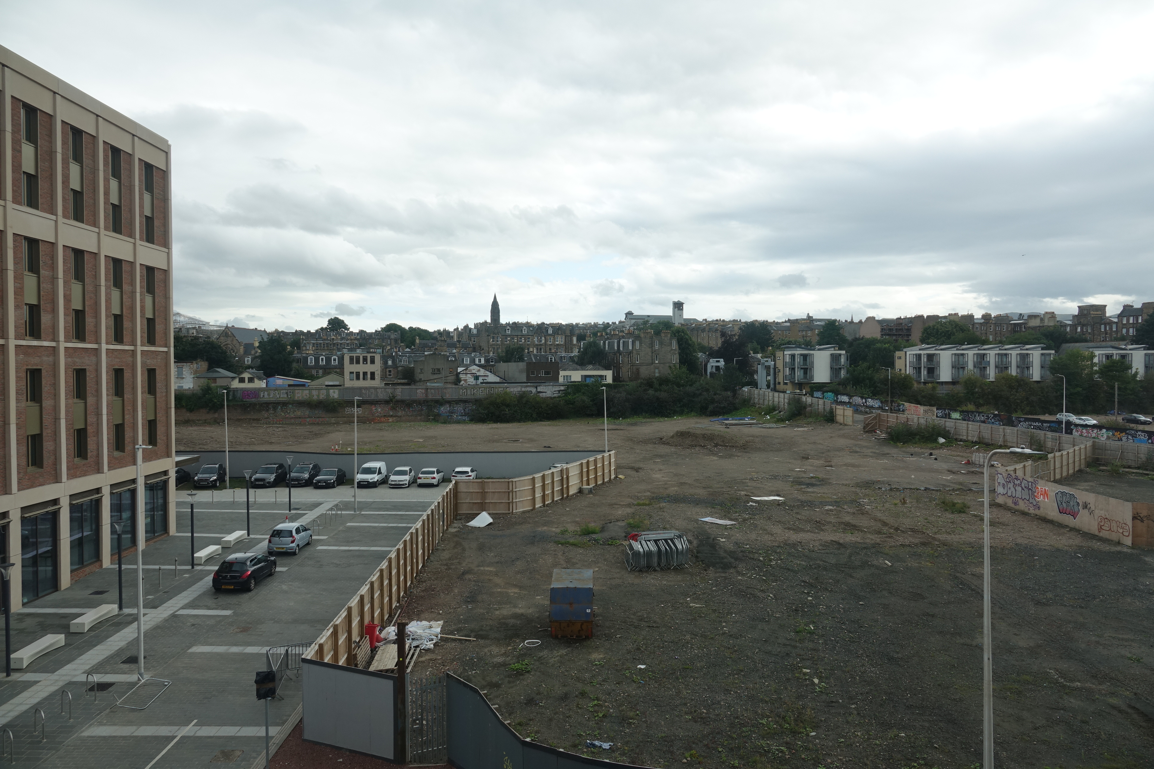 a parking lot with cars and buildings in the background