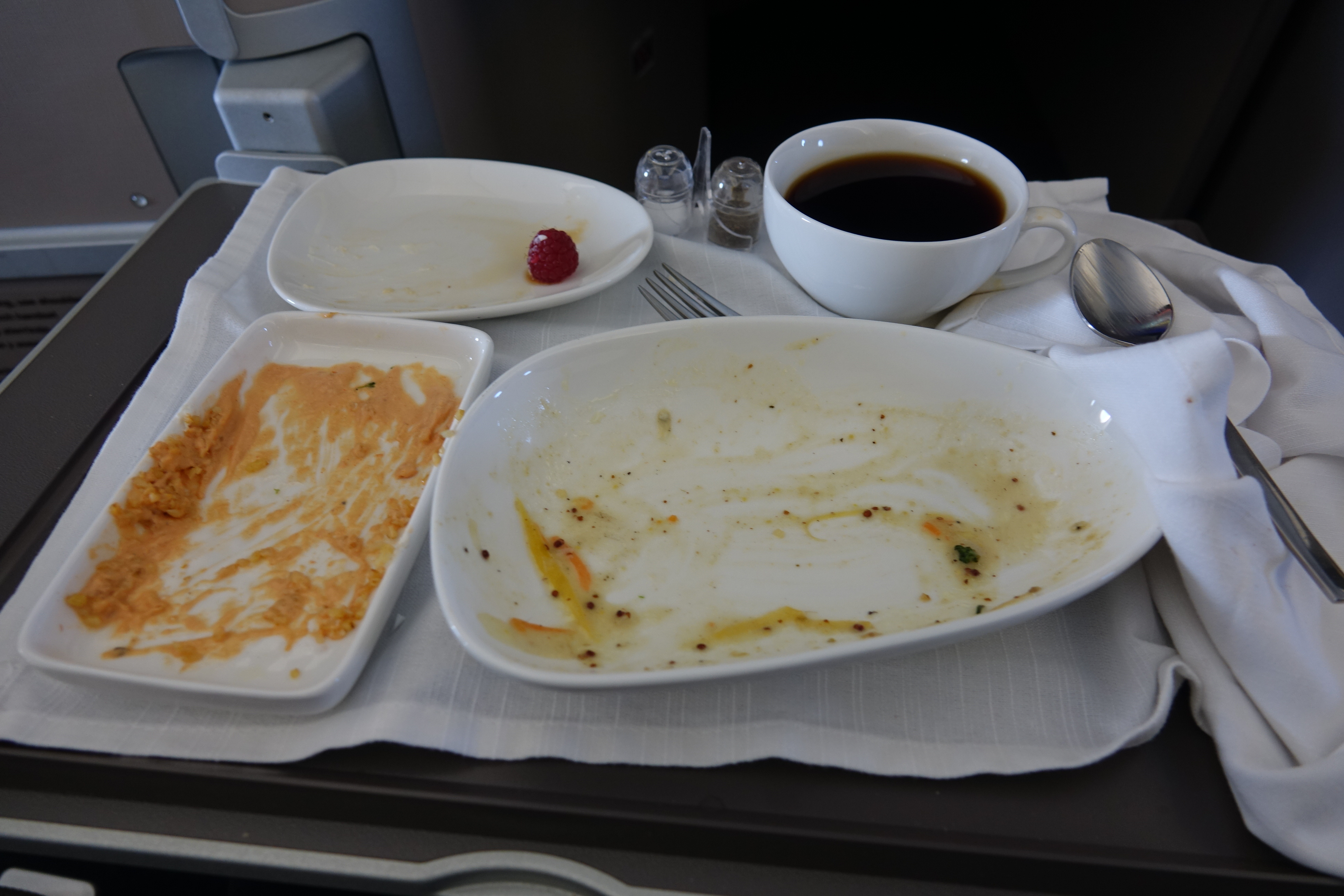 a plate with food and a cup of coffee on a table