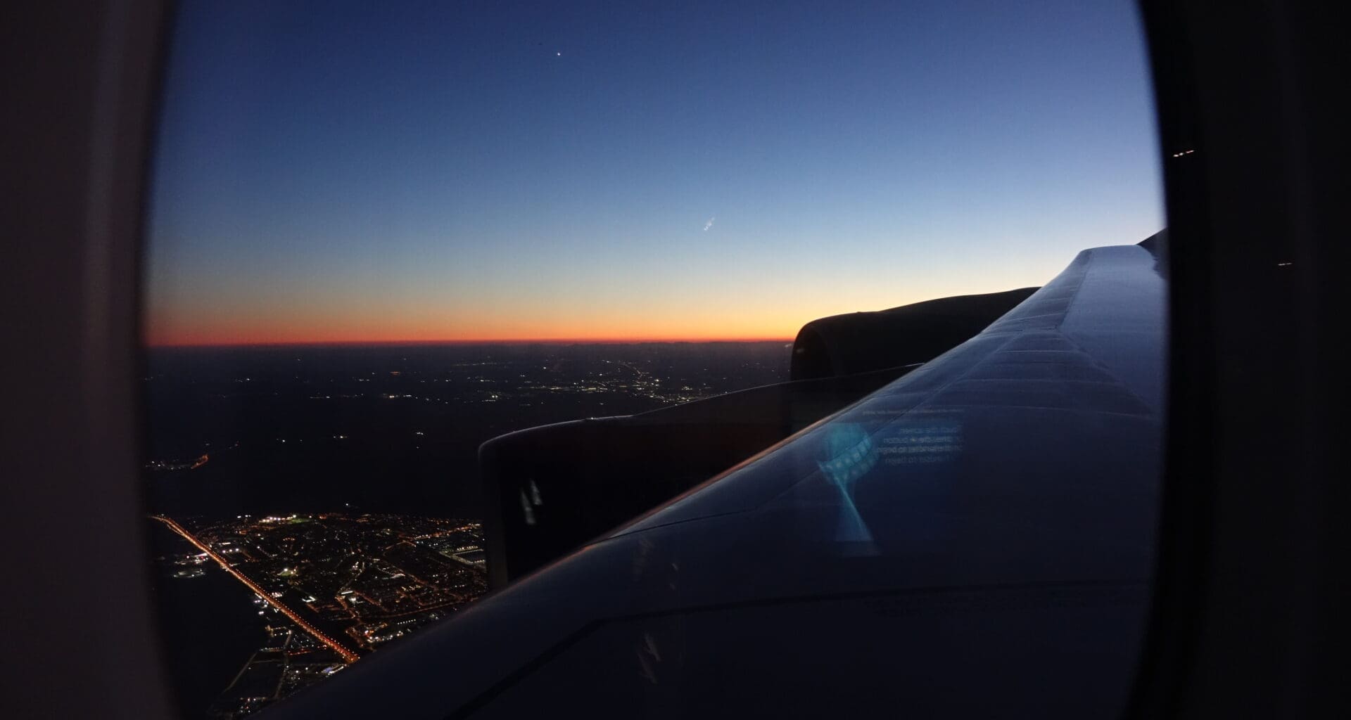 an airplane wing and a city at night