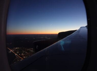 an airplane wing and a city at night