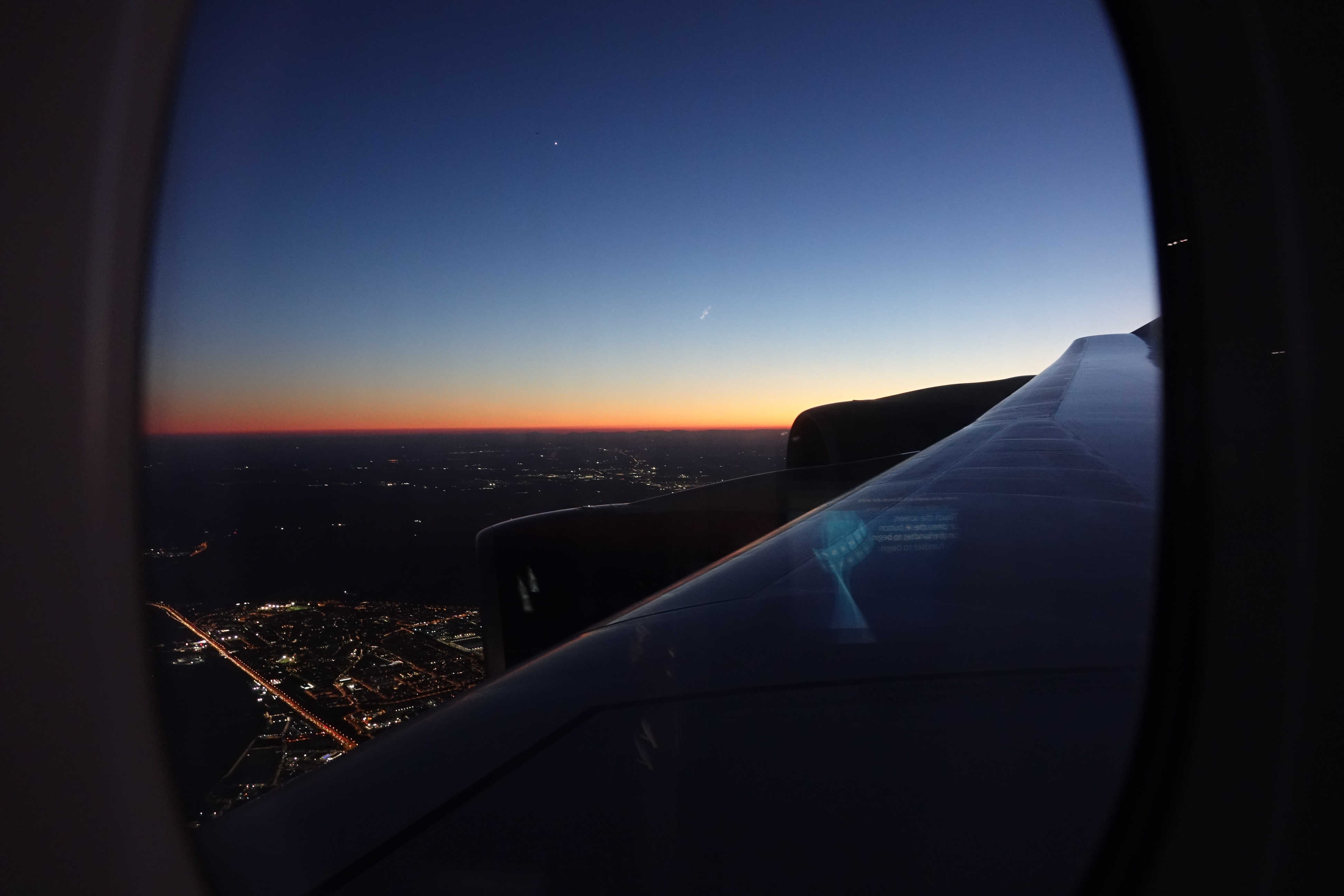 an airplane wing and a city at night