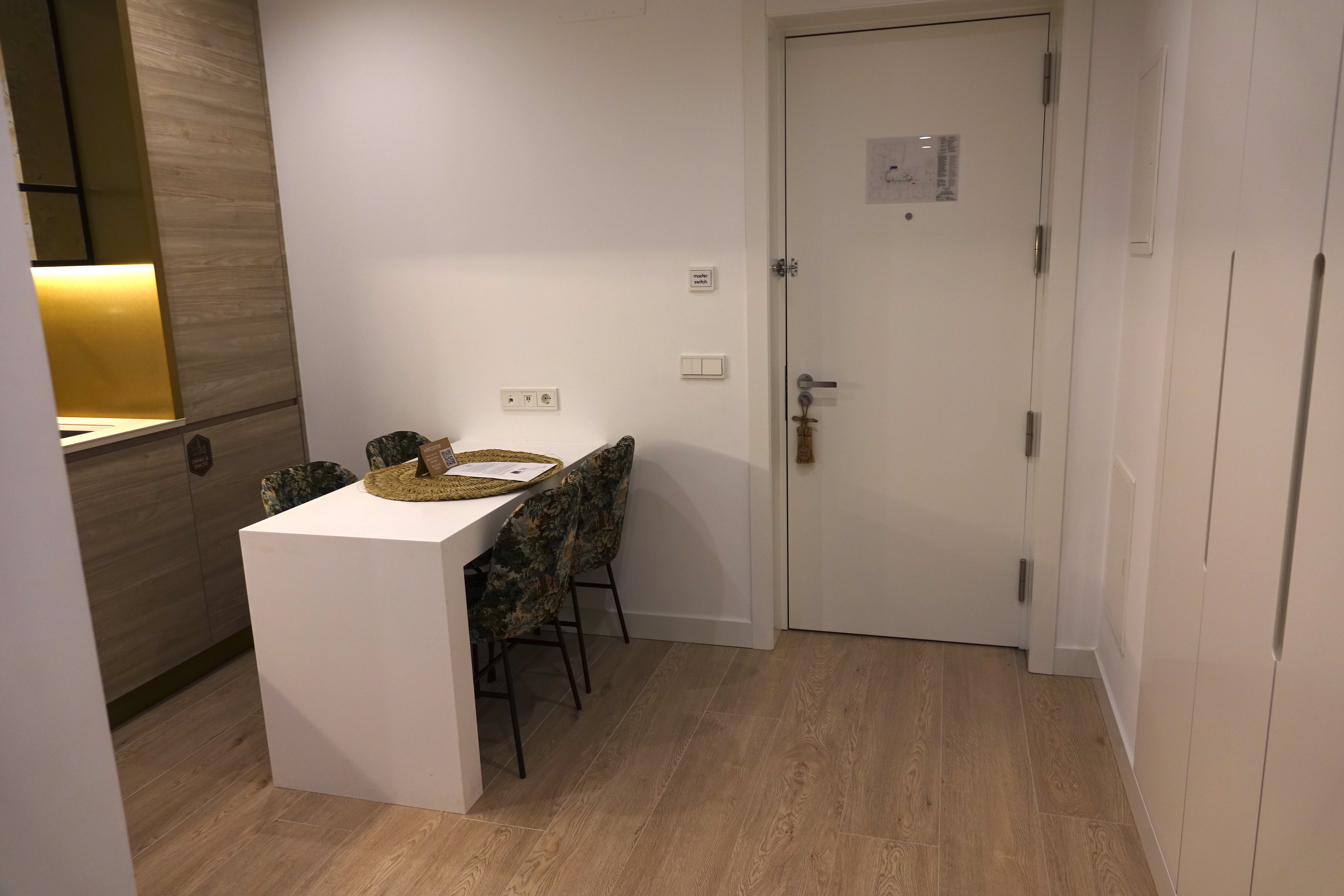 a white table with chairs in a room with a door