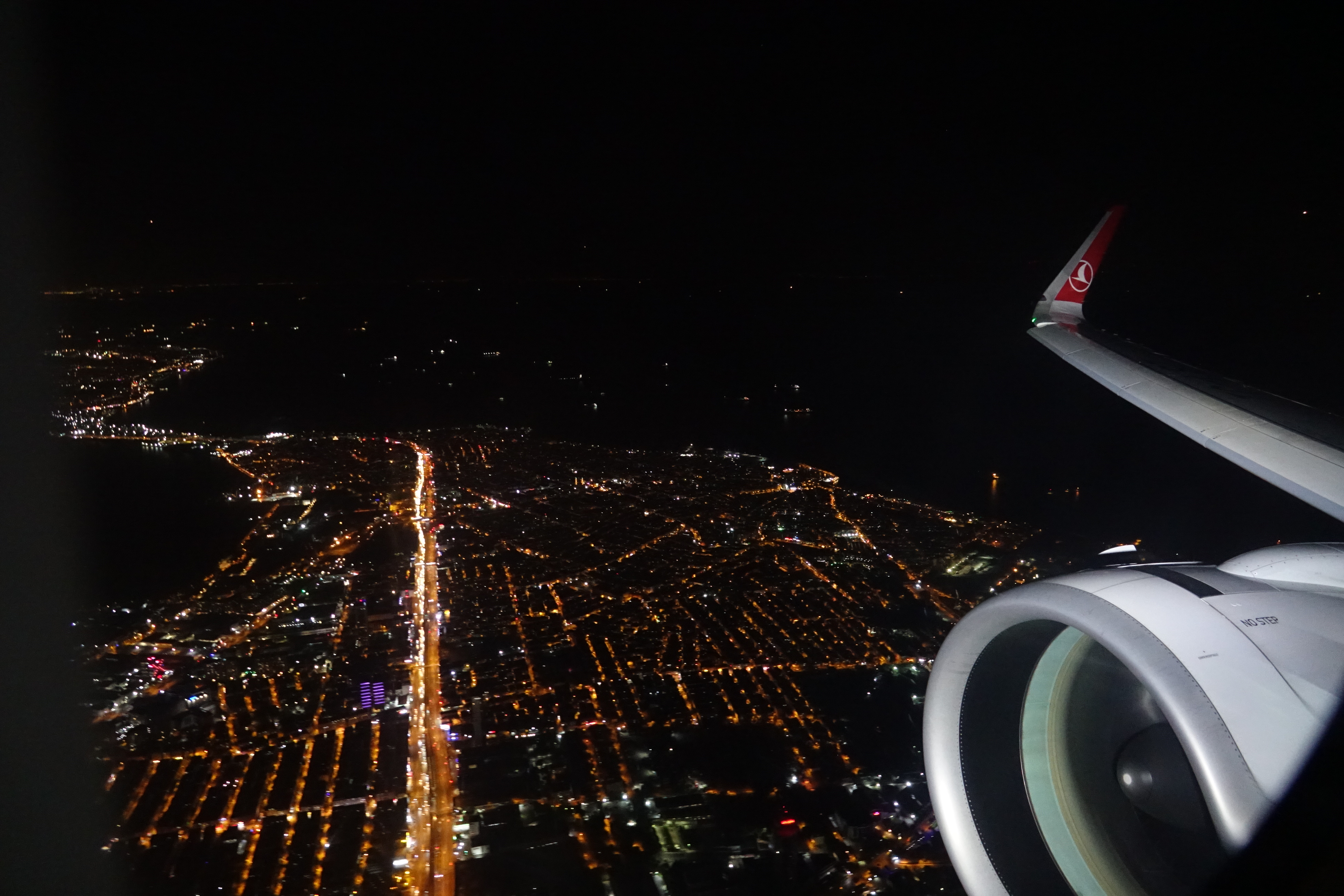 an airplane wing and a city at night