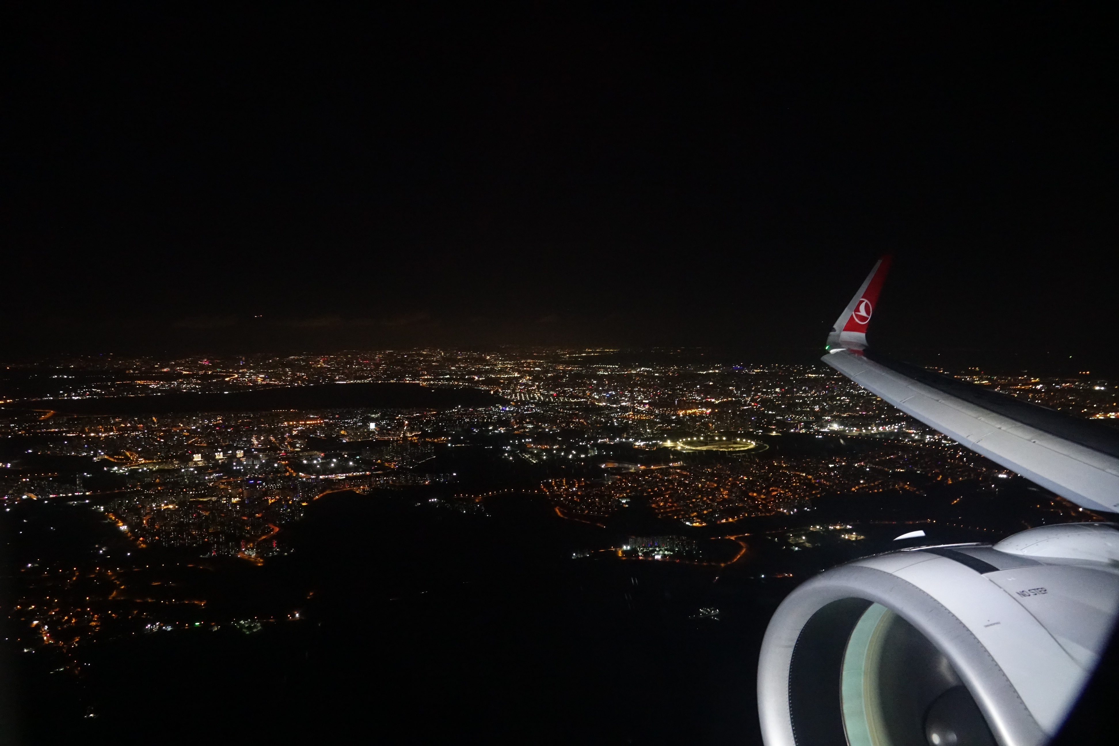 an airplane wing and a city at night