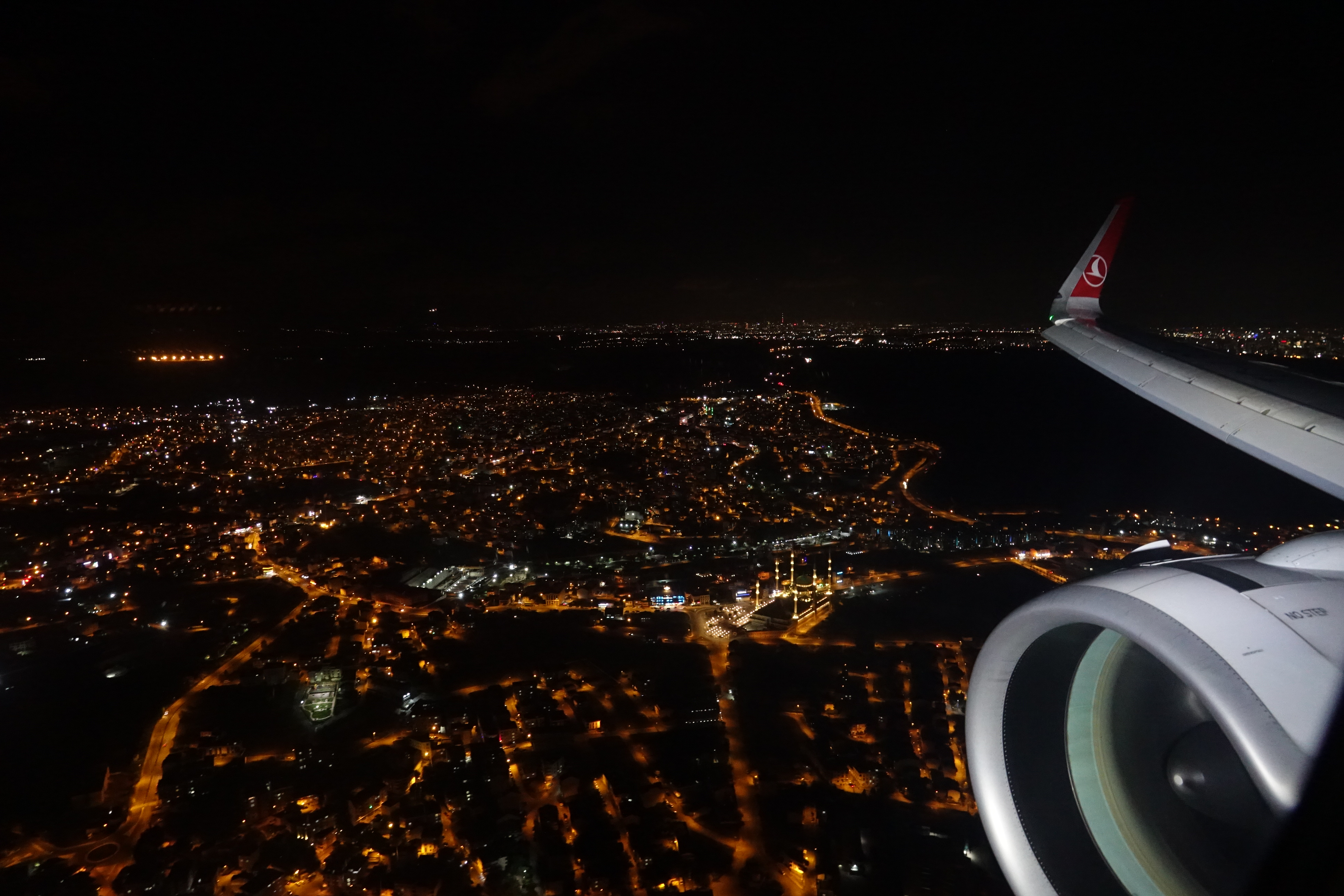 an airplane wing and a city at night