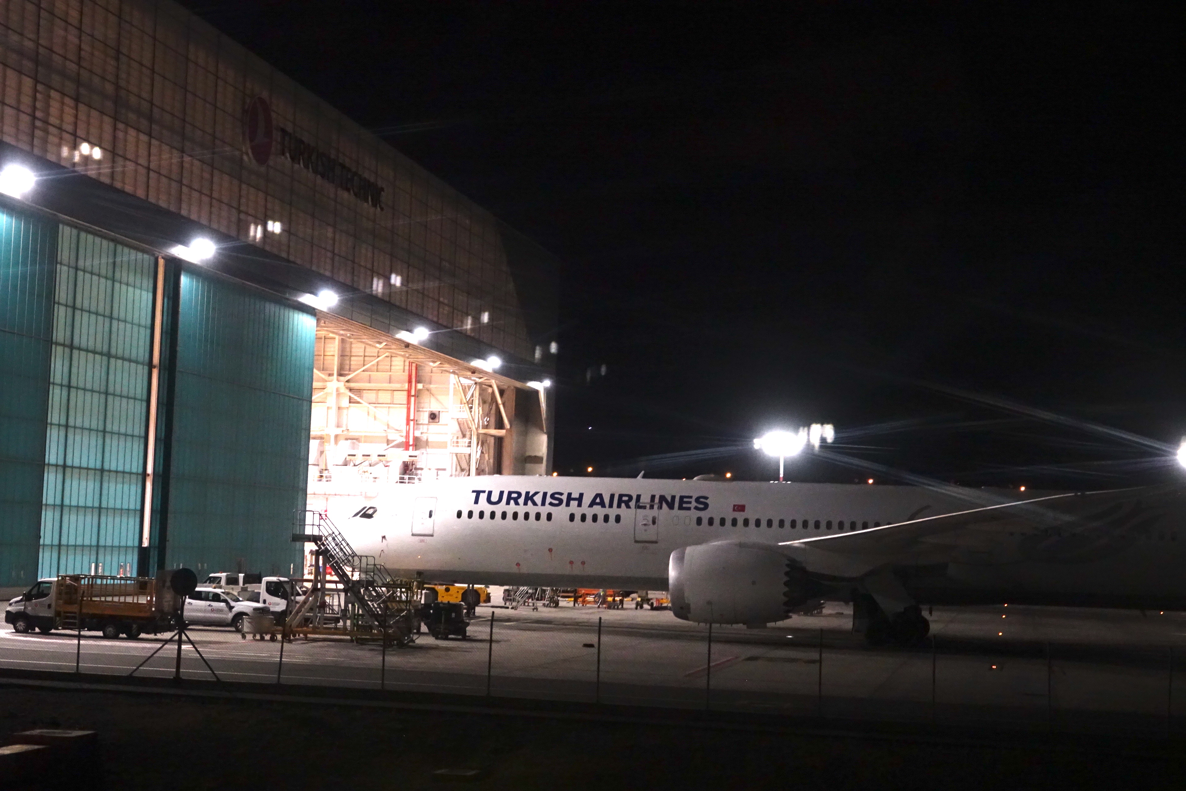 an airplane parked in a hangar at night