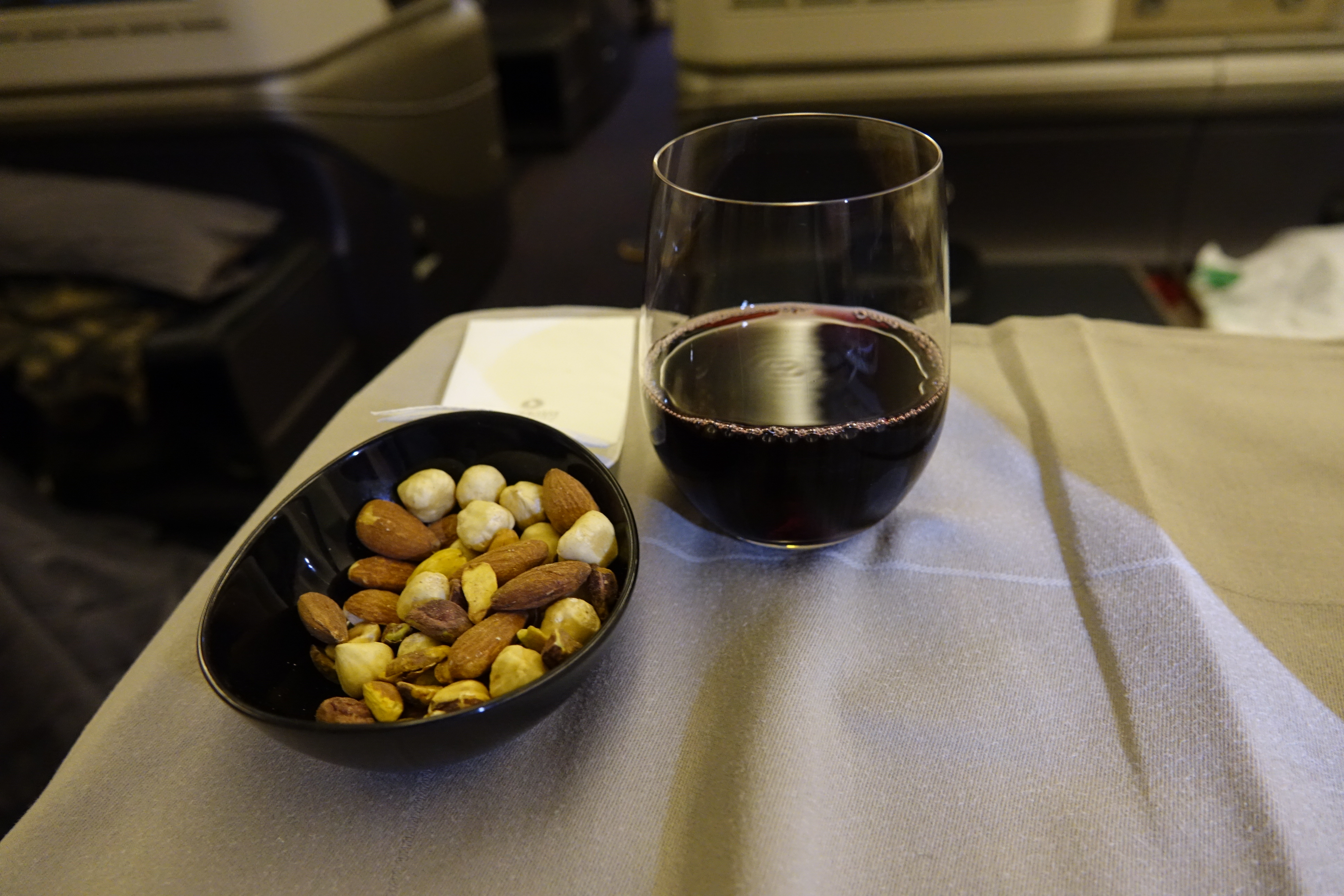 a bowl of nuts and a glass of wine