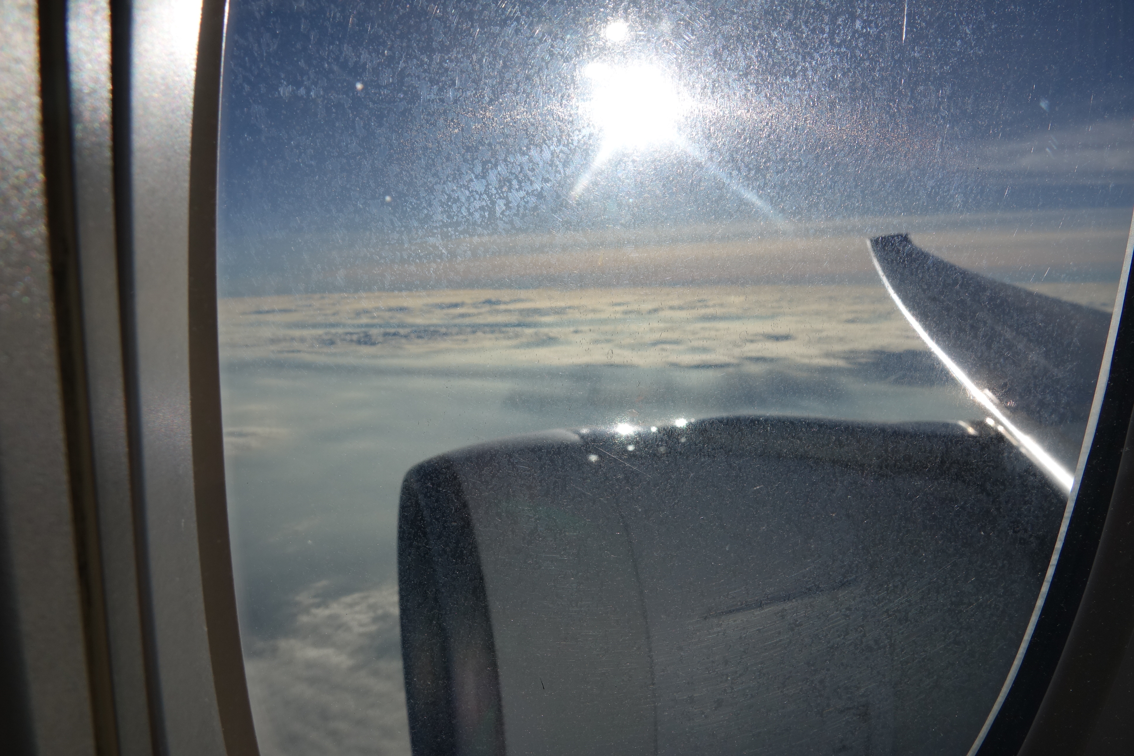 a view of clouds and the sun from an airplane window