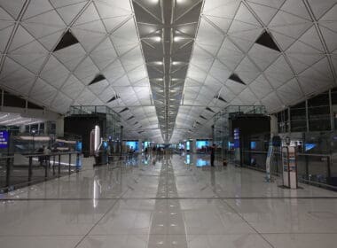 a large white tiled hallway with people walking around