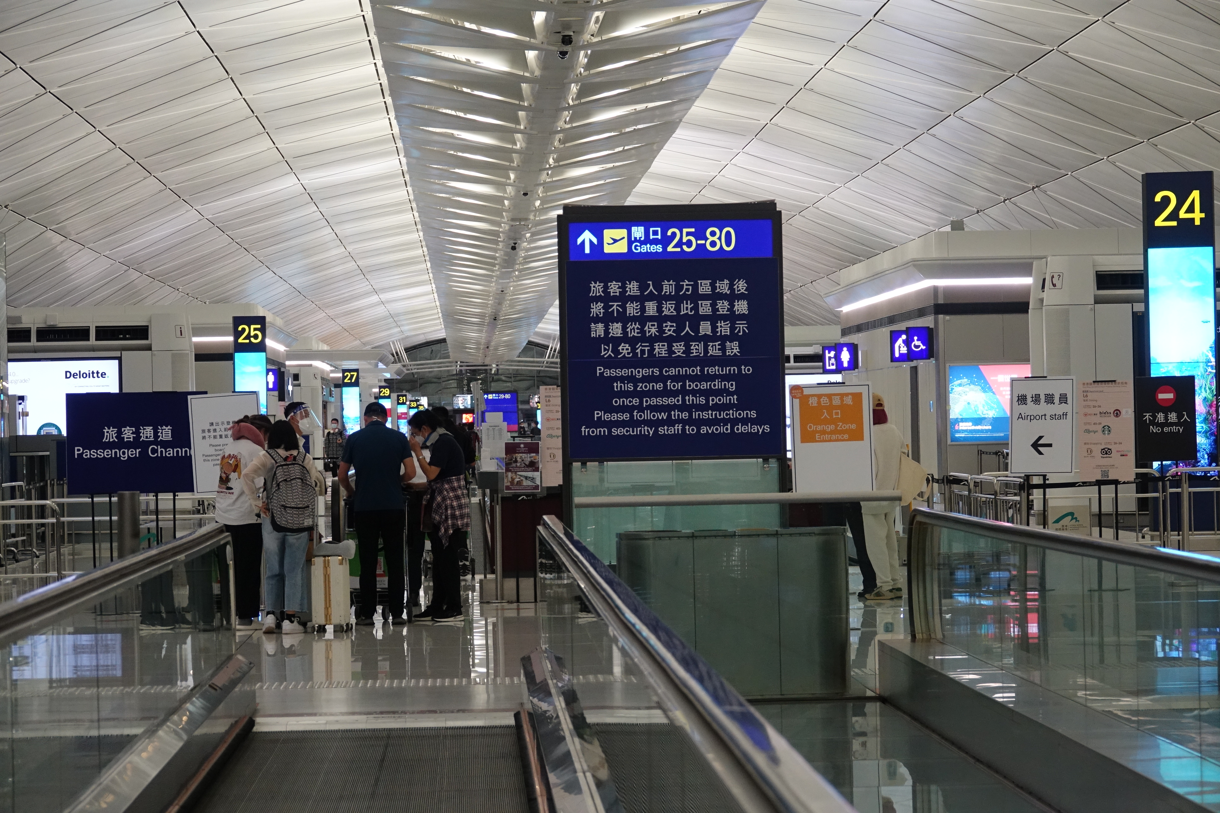 people in an airport with a sign