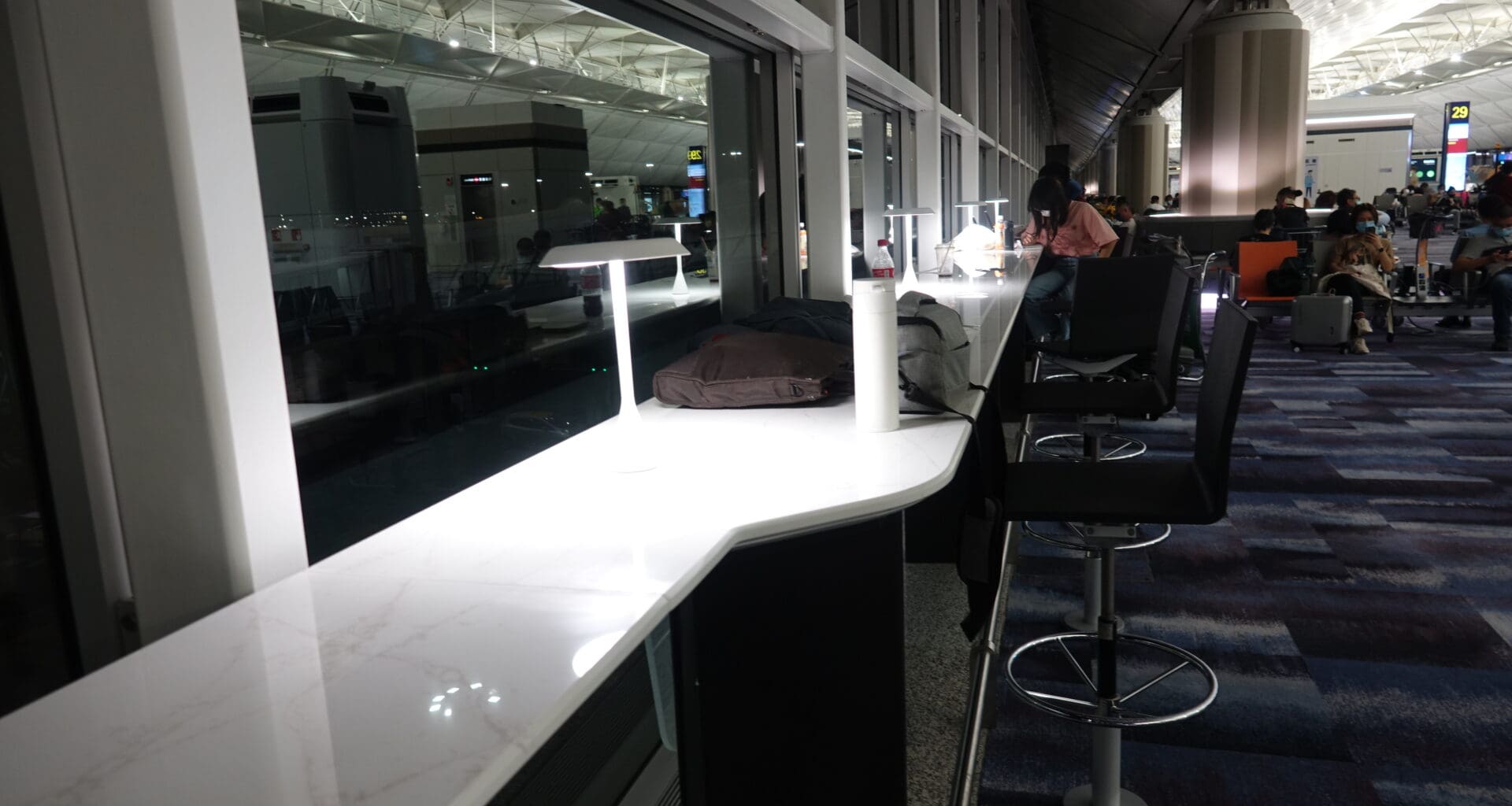 a counter with chairs and a lamp in a room with a large window