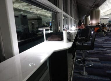 a counter with chairs and a lamp in a room with a large window