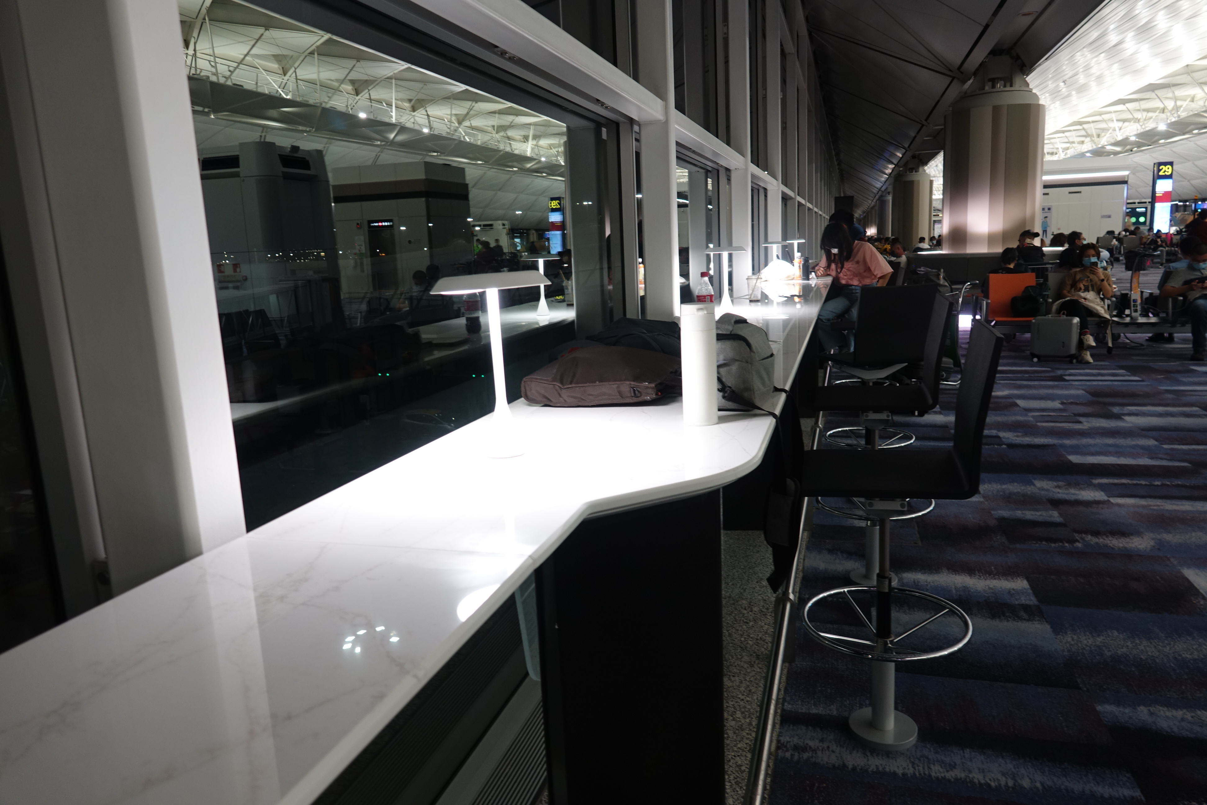 a counter with chairs and a lamp in front of a window