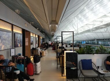 a group of people sitting in a room with chairs and tables