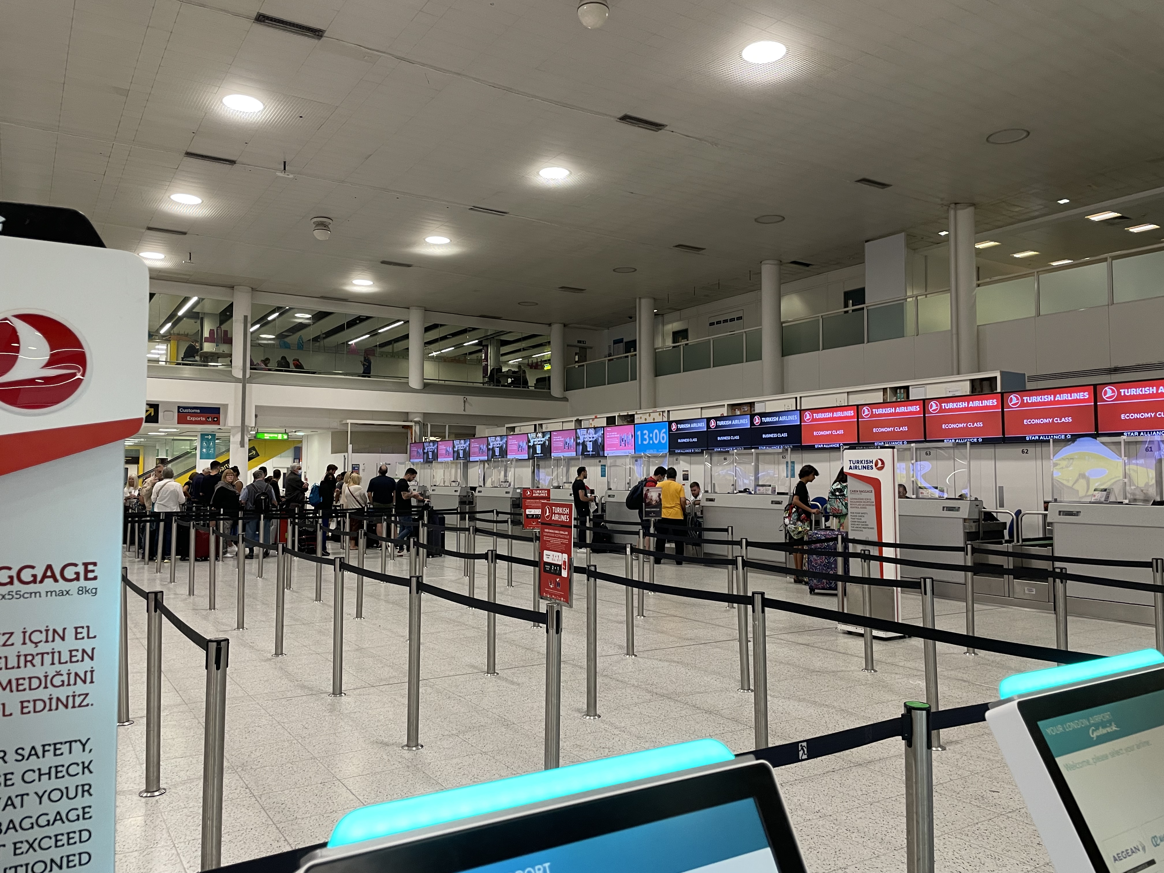 people in an airport with a row of screens