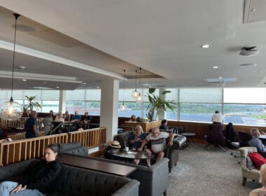 a group of people sitting in a room with a large window