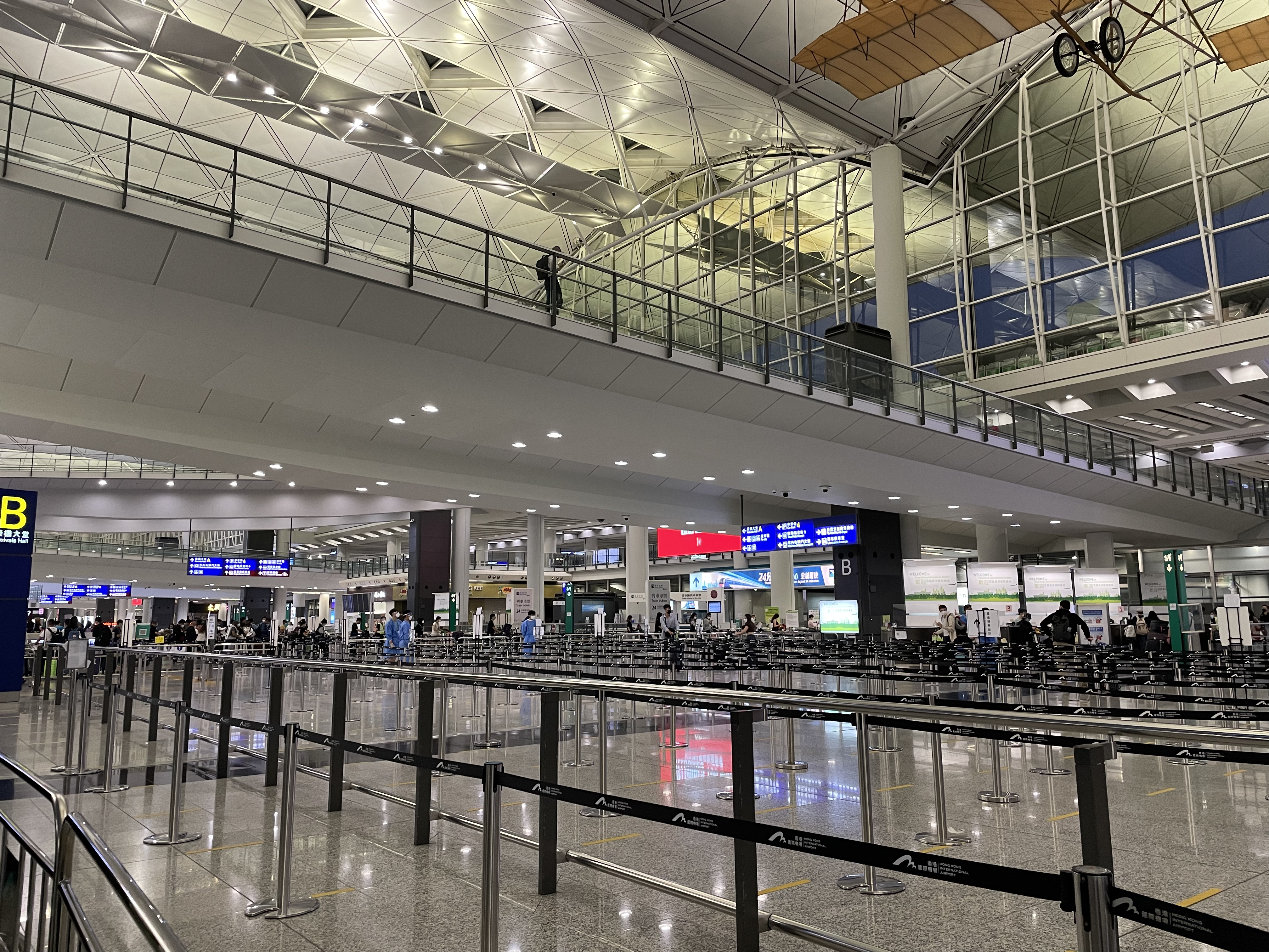 a airport with a glass ceiling and a walkway