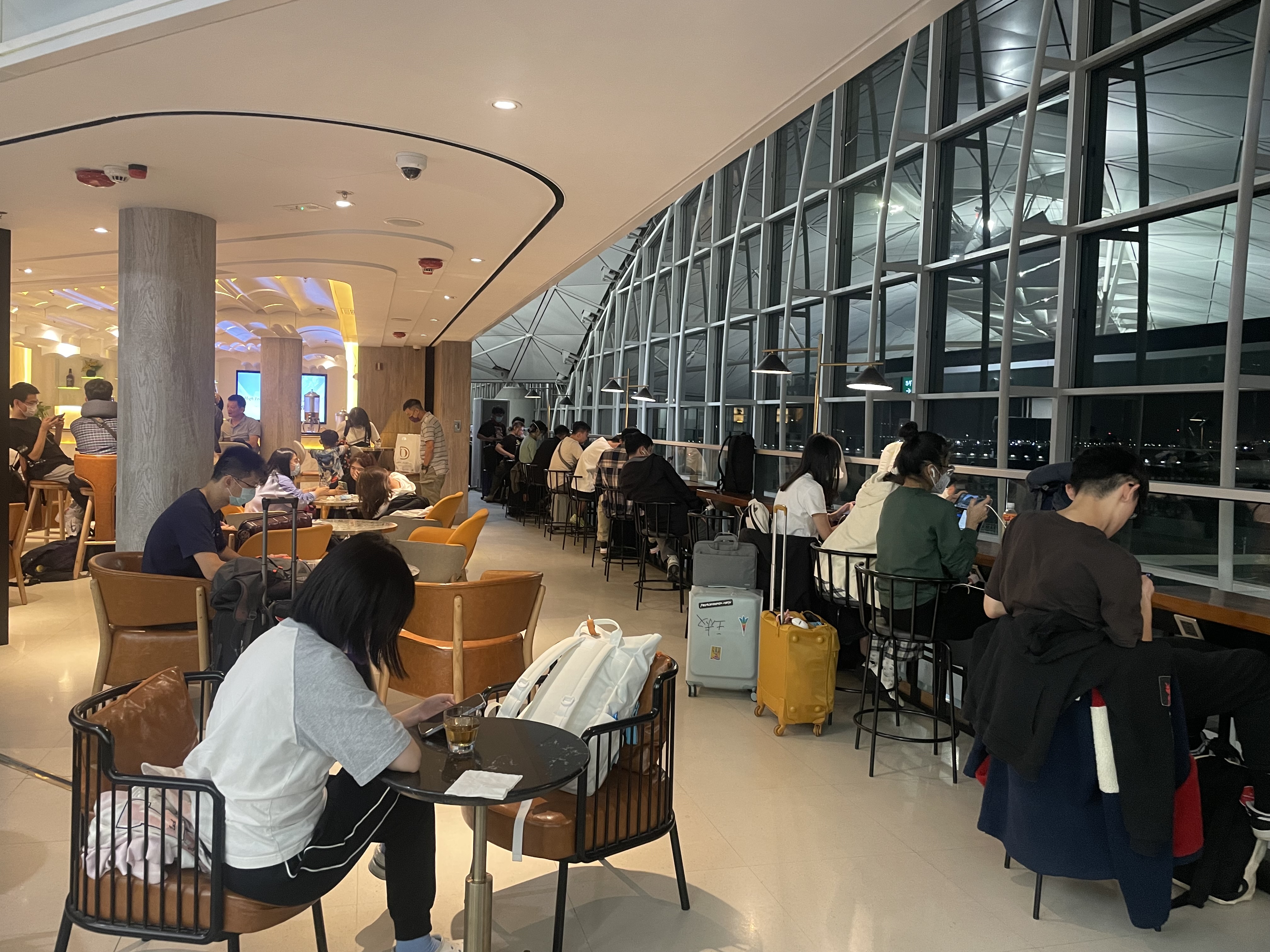 a group of people sitting at tables in a room with windows