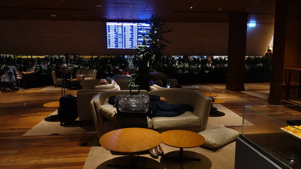 a man sleeping on a couch in a room with a sign