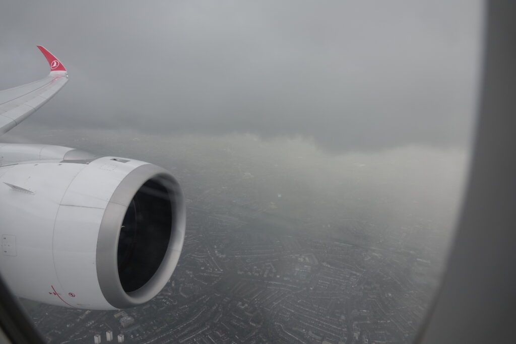 an airplane wing with a city in the background