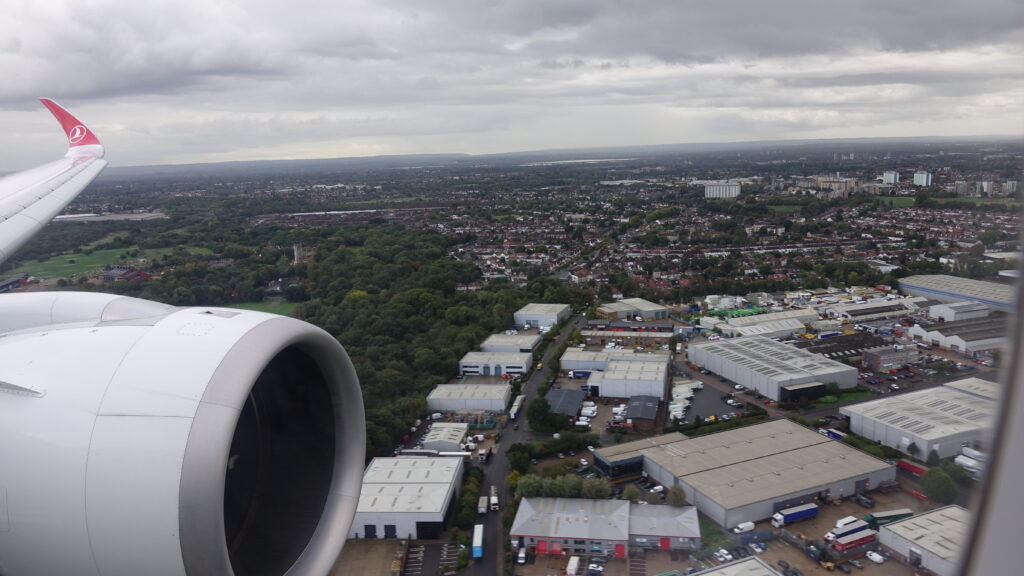 an airplane wing with a city in the background