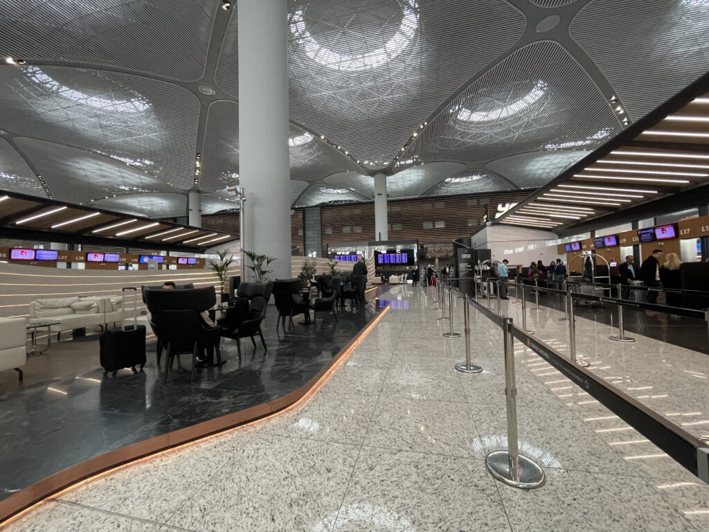 a large airport terminal with people waiting for their flight