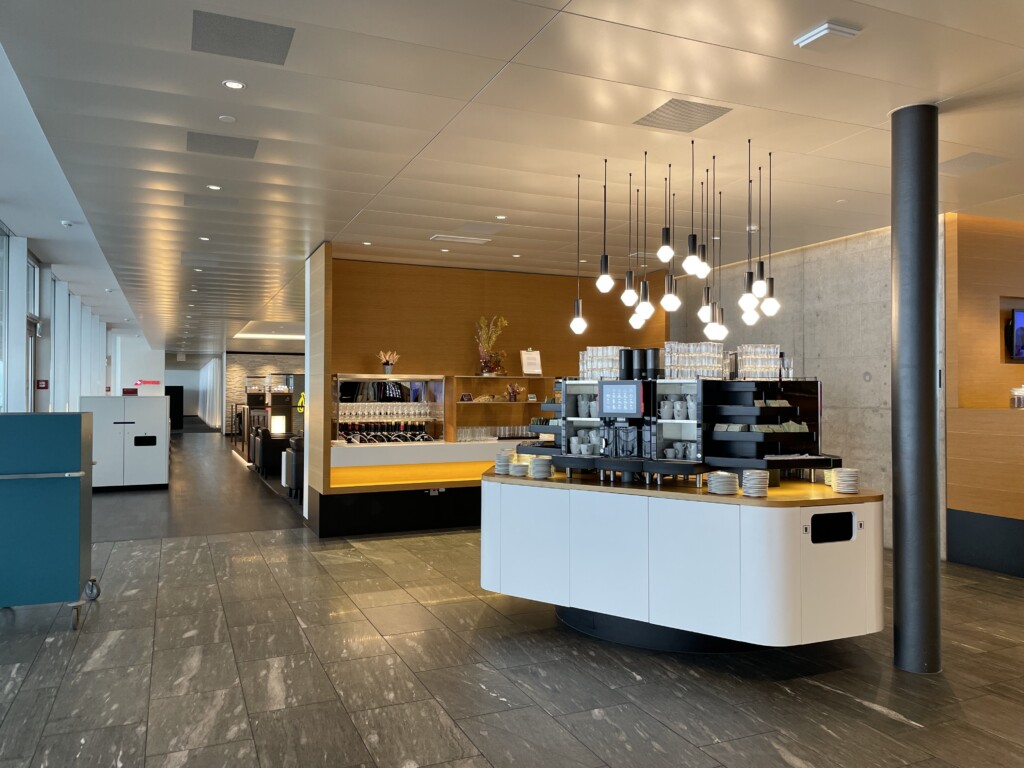 a coffee shop with a counter and lights from the ceiling