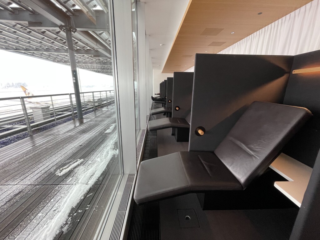 a row of black chairs in a room with a window