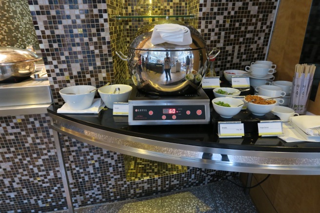 a silver pot with a silver bowl on a counter