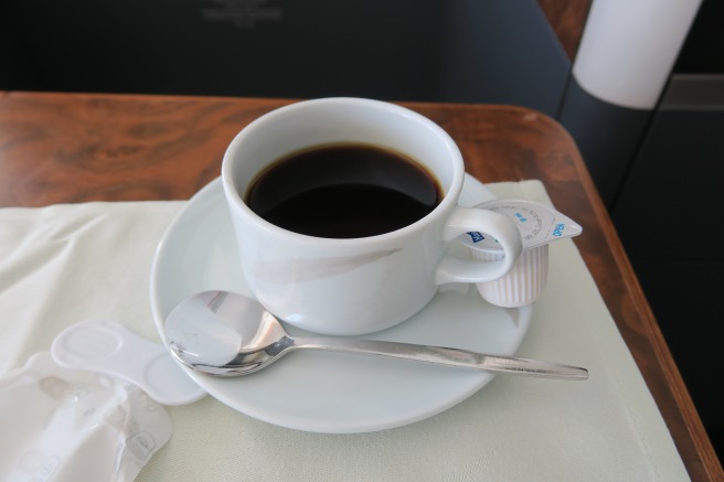 a cup of coffee on a saucer and a spoon