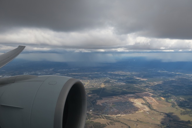 an airplane wing and engine above a city