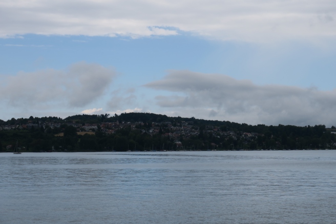 a body of water with a hill in the background