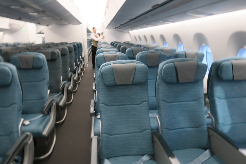 a man standing in a row of blue seats