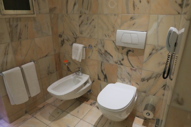 a bathroom with a toilet and bidet