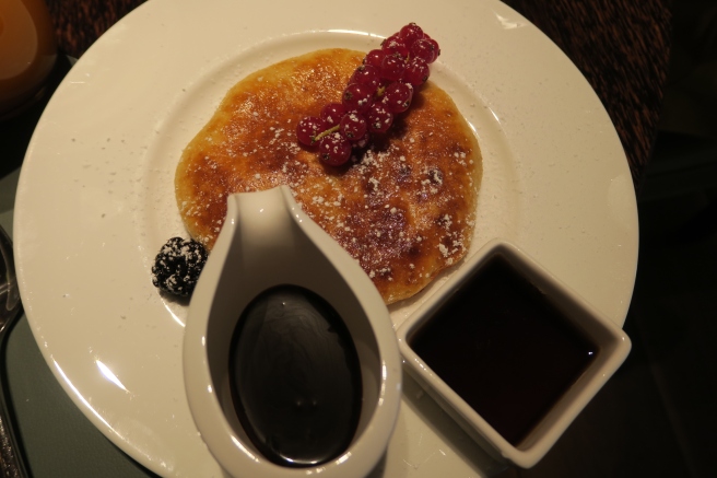 a plate of food with syrup and fruit