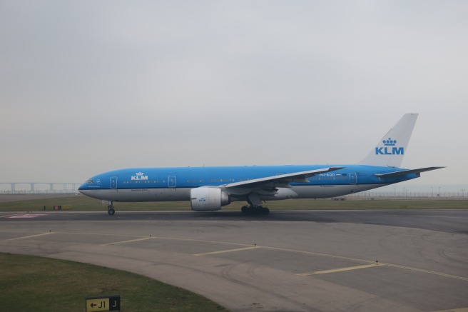 a blue and white airplane on a runway