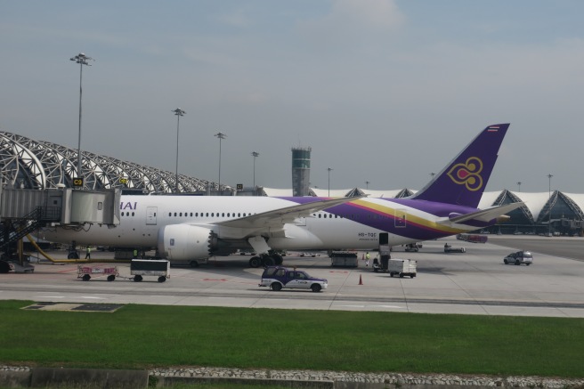 a large white and purple airplane on a runway